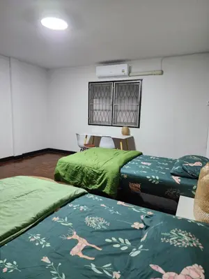 two beds in a room with green blankets at Creative Bangkok twin bed in Sathani Bang Khen