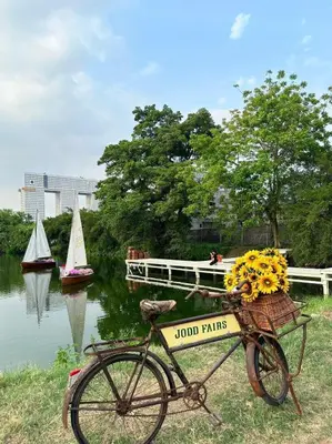 a bike parked next to a river with boats at Pannapat Place in Bangkok