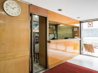 a clock on a wall next to a room at Muangphol Mansion in Bangkok