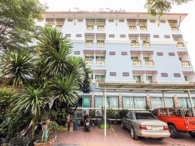 a large white building with cars parked in front of it at Thai Garden Resort in Bangkok