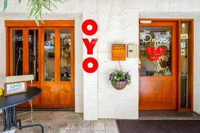 a building with wooden doors and a basket of flowers at OYO 895 The Onion Hostel in Bangkok