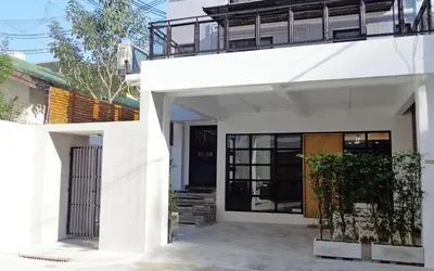 a white house with a door and a balcony at Silom Studios in Bangkok