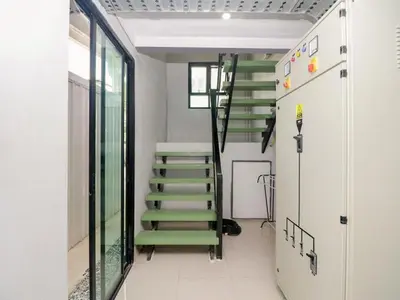 a hallway with green stairs in a building at Delighted Bangkok Hotel in Bangkok