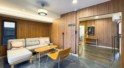 a waiting room with a couch and a table and chairs at Hyde Residence Ladprao48 in Bangkok