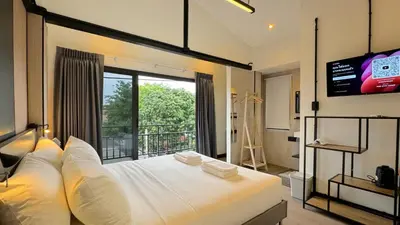 a bedroom with a white bed with a large window at Hyde Residence Ladprao48 in Bangkok