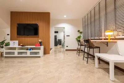 a living room with a tv on a wall at Coco59- Private 3BR Pool Villa in Bangkok