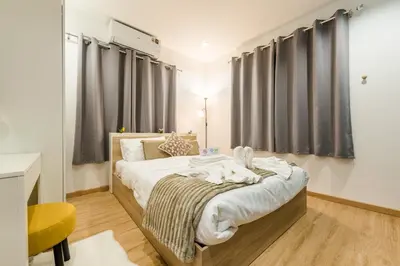 a bedroom with two beds and a yellow chair at Coco59- Private 3BR Pool Villa in Bangkok