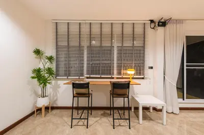 a kitchen with a table and stools in front of a window at Coco59- Private 3BR Pool Villa in Bangkok