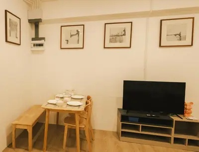 a living room with a table and a television at City Silom I King Bed I Sleep 3 I 2 Bedroom in Bangkok