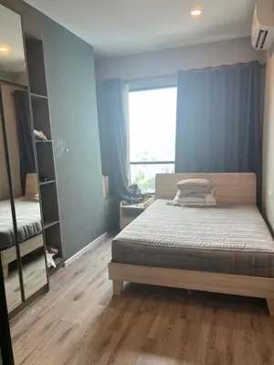 a bedroom with a bed and a large window at KnIGHTSBRIDGE in Bangkok