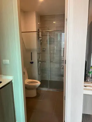 a bathroom with a toilet and a glass shower at KnIGHTSBRIDGE in Bangkok
