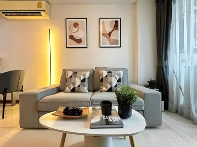 a living room with a couch and a table at Stylish Low-rise 1BR - Ultra Fast WiFi - BTS Thonglor in Bangkok