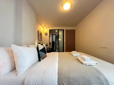 a bedroom with a large white bed with towels on it at Stylish Low-rise 1BR - Ultra Fast WiFi - BTS Thonglor in Bangkok