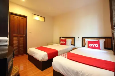 a hotel room with two beds with red pillows at Pannee Lodge Khaosan - SHA Plus in Bangkok
