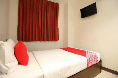 a bedroom with a bed with red pillows and a window at Super OYO 484 Pannee Residence Khaosan Sha Plus in Bangkok