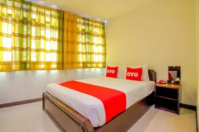 a bedroom with a large bed with two red pillows at Super OYO 484 Pannee Residence Khaosan Sha Plus in Bangkok
