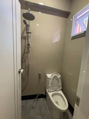 a small bathroom with a toilet and a shower at Apartment Near Big Buddha in Bangkok Yai