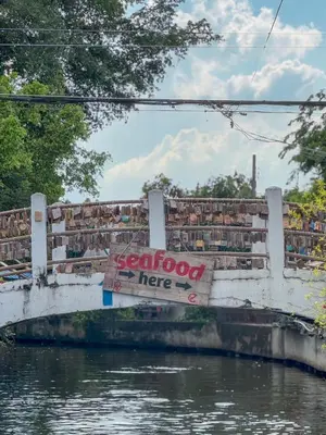 a sign on a bridge over a body of water at Apartment Near Big Buddha in Bangkok Yai
