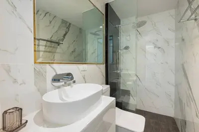 a white bathroom with a sink and a shower at Stylish 7Beds Poolhouse with Cinema Lift - 2min to BTS in Amphoe Phra Khanong