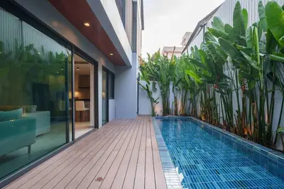 a swimming pool on the side of a building with plants at MonochromeDesignerPool Villa in Bangkok