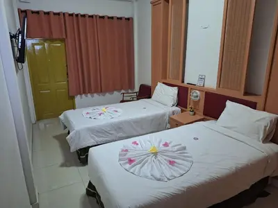 a hotel room with two beds with flowers on them at Happy 2 Hotel Patunam in Bangkok