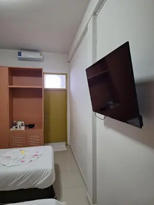 a flat screen tv hanging on a wall in a room at Happy 2 Hotel Patunam in Bangkok