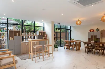 a room with wooden chairs and tables and windows at Shizuka House - 500 m walk to BTS Phrom Phong in Bangkok