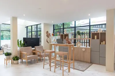 a living room with a table and chairs and a tv at Shizuka House - 500 m walk to BTS Phrom Phong in Bangkok