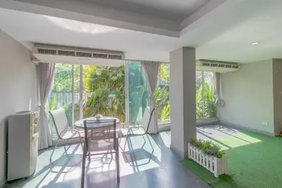 a dining room with a table and chairs and a large window at Resortel Lat Phrao 91 in Bangkok