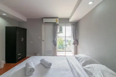 a bedroom with a large white bed with towels on it at Resortel Lat Phrao 91 in Bangkok