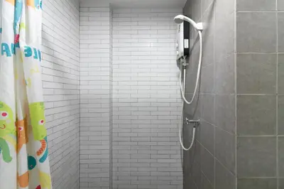 a shower in a bathroom with a shower curtain at Resortel Lat Phrao 91 in Bangkok