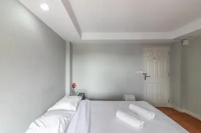 a bedroom with a white bed with two pillows on it at Resortel Lat Phrao 91 in Bangkok