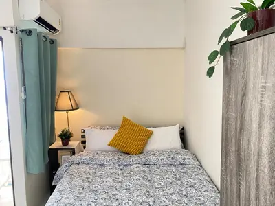 a bedroom with a bed with a yellow pillow at Tiny Nest Pratunum Airport Link in Pratunam