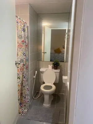 a bathroom with a toilet and a mirror at Tiny Nest Pratunum Airport Link in Pratunam