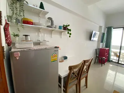 a kitchen with a refrigerator and a table with chairs at Tiny Nest Pratunum Airport Link in Pratunam