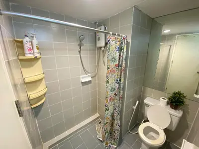 a bathroom with a shower with a toilet and a sink at Tiny Nest Pratunum Airport Link in Pratunam