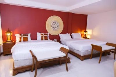 two beds in a room with red walls at Elite Home stays by UPAR, Silom in Bangkok