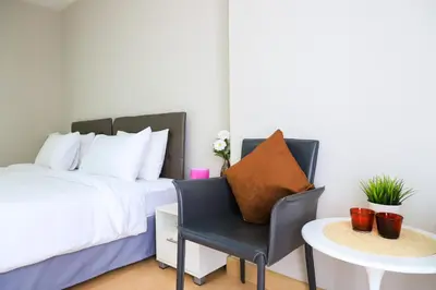 a bedroom with a bed and a chair and a table at CU iHouse เรือนวิรัชมิตร in Bang Rak
