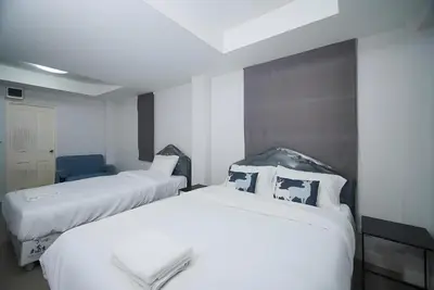 two beds in a hotel room with white sheets at XX Mitr Inn The Grand Palace Bangkok - Samyot in Bangkok