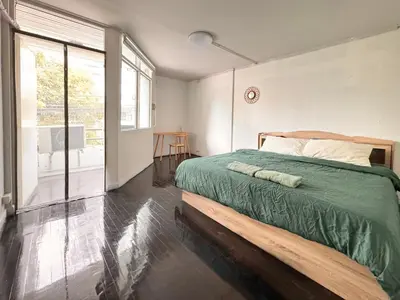 a bedroom with a large bed and a large window at Cozy Cat Souluna home in Ekkamai in Bangkok
