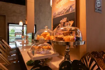a display of pastries in glass containers on a table at The Riche Boutique Hotel Don Mueang Airport in Bangkok