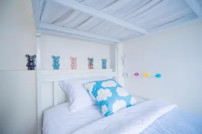 a white bed with a pillow on it in a room at Via Baan Sathorn, City-Center Apartment With Private Rooftop Near BTS in Bangkok
