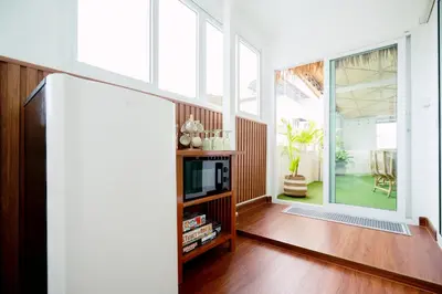 a living room with a large window and a tv at Via Baan Sathorn, City-Center Apartment With Private Rooftop Near BTS in Bangkok