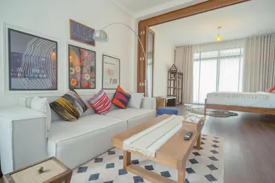 a living room with a white couch and a table at Via Baan Sathorn, City-Center Apartment With Private Rooftop Near BTS in Bangkok