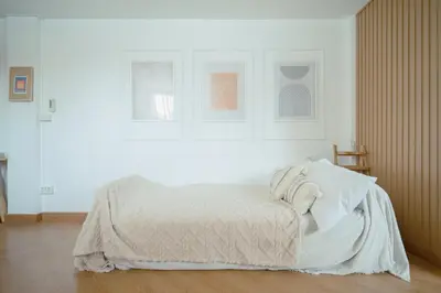 a white bedroom with a bed with white sheets at Via Baan Sathorn, City-Center Apartment With Private Rooftop Near BTS in Bangkok