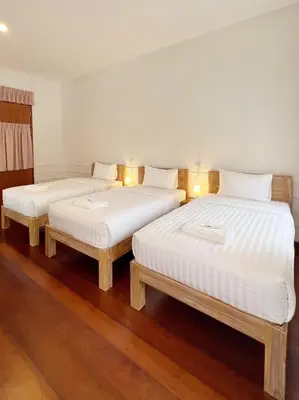 two twin beds in a room with wooden floors at Au samlor guesthouse in Chinatown
