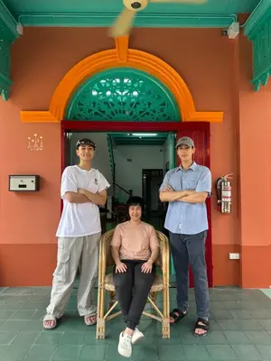 three men standing in front of a building with their arms crossed at Au samlor guesthouse in Chinatown