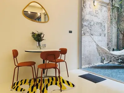 a dining room table with two chairs and a mirror at Charming Minimal 3BR Home Near BTS Ari, Bangkok in Sathani Bang Su