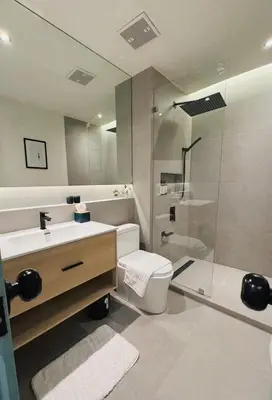 a bathroom with a toilet and a sink and a shower at Charming Minimal 3BR Home Near BTS Ari, Bangkok in Sathani Bang Su