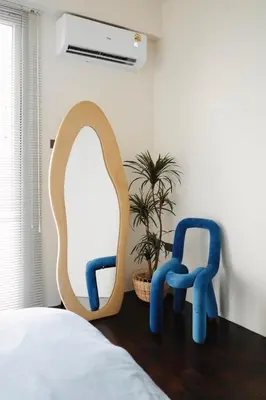 a bedroom with two blue chairs and a mirror at Charming Minimal 3BR Home Near BTS Ari, Bangkok in Sathani Bang Su